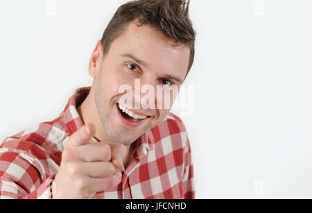 Jeune homme en chemise hippie pointant son doigt vers la caméra et standing against white background concept émotionnel. Banque D'Images