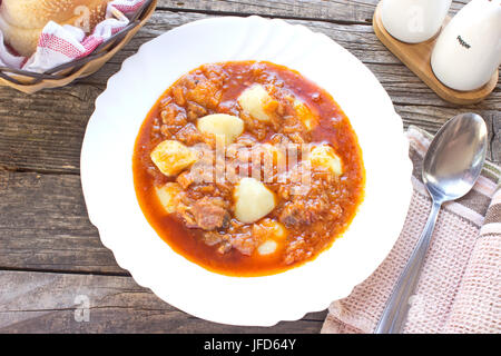 Soupe de goulash hongrois dans la plaque sur la table en bois Banque D'Images