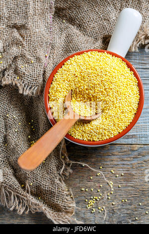 Les graines de millet dans un bol en céramique. Banque D'Images