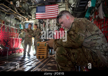 Le sergent de l'US Air Force. Thomas Parris, 17e Escadron d'opérations spéciales MC-130J, arrimeur Commando II reviews une liste de contrôle en amont dans le cadre d'une mission de formation Lancement de masse 22 juin 2017, à Kadena Air Base, au Japon. Le MC-130J était un des quatre autres qui volaient en formation et terminé la formation sur Ie Shima airdrop, Okinawa. (U.S. Photo de l'Armée de l'air par les cadres supérieurs d'un membre de la John Linzmeier) Banque D'Images