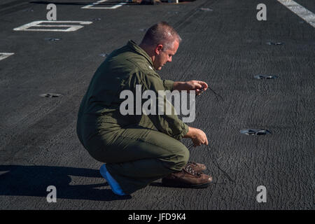 1706627-N-AZ808-105 OCÉAN PACIFIQUE (27 juin 2017) - Le Cmdr. Dennis Metz, le mini-boss à bord du porte-avions USS Theodore Roosevelt (CVN 71) se prépare pour un tournage d'amorçage sur le poste de pilotage. Les pousses de démarrage sont une tradition maritime dans laquelle une cérémonie a lieu pour le tireur au départ par le lancement d'une paire de bottes hors du navire par catapulte. Theodore Roosevelt est actuellement en cours au large de la côte de Californie du Sud. (U.S. Photo par marine Spécialiste de la communication de masse/Burgains Nicholas marin libéré) Banque D'Images