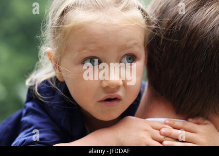 Peu effrayé girl hugging père Banque D'Images