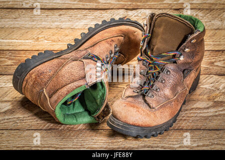 Une paire de vieux, bien usé, des bottes de randonnée sur Weathered Wood Banque D'Images