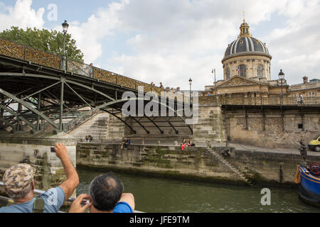 Les touristes voir l'Institut français et le Pont des Arts, ou l'amour Lock Bridge, à partir d'un bateau d'une croisière sur la Seine. Banque D'Images