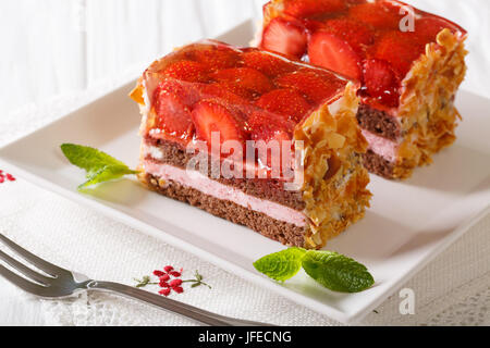 Gâteau aux amandes Chocolat Fraise close-up sur une plaque sur une table horizontale. Banque D'Images