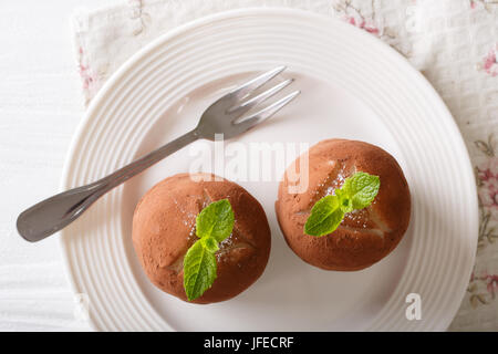 Boules de rhum à la menthe et gâteaux de poudre de cacao dans une assiette sur la table horizontale vue du dessus. Banque D'Images