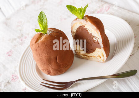 Tranches de gâteau au chocolat boules de rhum à la menthe et le cacao en poudre sur une assiette sur une table horizontale. Banque D'Images