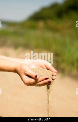 Dans sable mains de femme dans la plage Banque D'Images