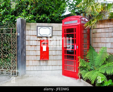 Cabine téléphonique anglaise traditionnelle et letterbox monté dans le mur. Banque D'Images