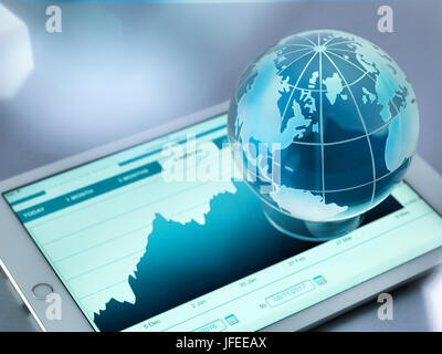 Un globe de verre illustrant le monde assis sur un tableau numérique montrant une augmentation de prix de l'action. Banque D'Images