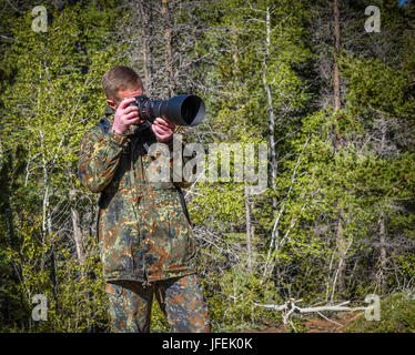 La faune, l'homme nature photographe en tenue de camouflage, prendre des photos de tournage Banque D'Images