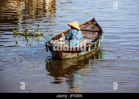 Femme dans une barque pour lookoing clients touristiques sur la rivière Thu Bon à Hoi An, Vietnam Banque D'Images