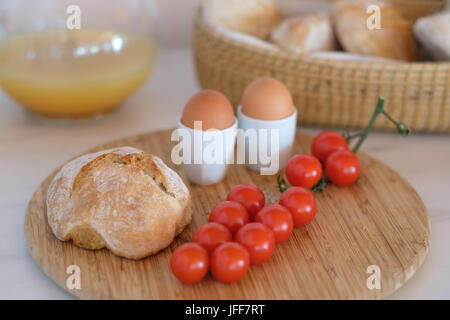 Petit-déjeuner sain avec des œufs durs, du pain, des tomates cerises et du jus d'orange Banque D'Images