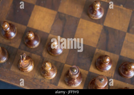 Pièces des échecs en bois Vintage sur un ancien échiquier. Banque D'Images