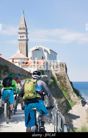 Les cyclistes VTT vers l'église par la mer Banque D'Images