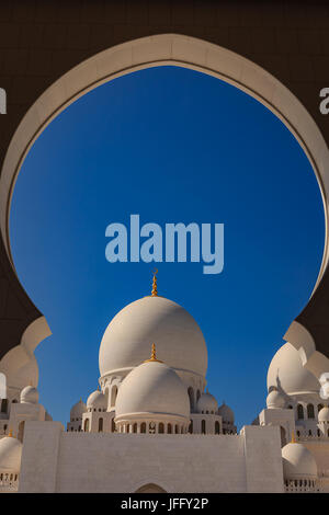 Abu Dhabi, UAE - Le centre des dômes de marbre sur la Grande Mosquée de Sheikh Zayed à Abu Dhabi aux Emirats Arabes Unis, encadrée par une arche Banque D'Images