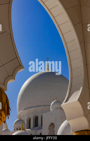 Abu Dhabi, UAE - Le centre des dômes de marbre sur la Grande Mosquée de Sheikh Zayed à Abu Dhabi aux Emirats Arabes Unis, encadrée par une arche Banque D'Images