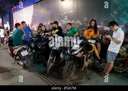 Les jeunes vietnamiens se tenir à côté de leurs motos à Ho Chi Minh Ville au Vietnam, Asie Banque D'Images