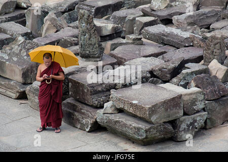 Le moine bouddhiste en vacances en utilisant son smartphone lors d'une visite à Angkor Wat temple complexe au Cambodge, en Asie Banque D'Images