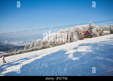 Skieur dans un casque rouge debout sur l'ascenseur Banque D'Images