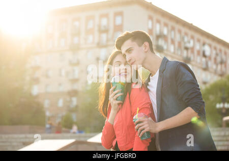 Les adolescents boivent fruits frais de lunettes. Embrasser doucement. Couple dans l'amour. La Romance du premier amour. Banque D'Images