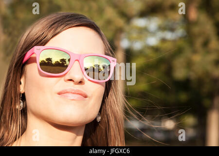 Jeune femme avec des lunettes de soleil rose Banque D'Images