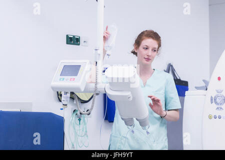 Nurse holding bouteille glucose et d'exploitation de la machine médicale Banque D'Images