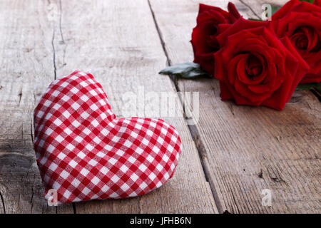 Roses rouges et un coeur sur fond de bois Banque D'Images