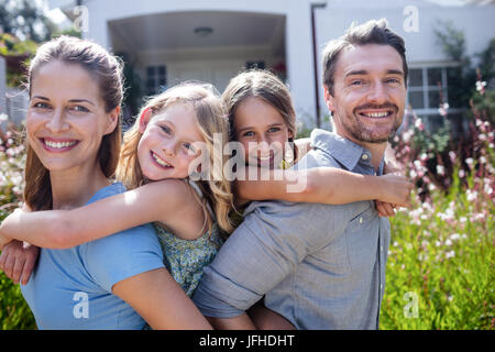 Portrait de parents donnant un piggy back pour filles Banque D'Images