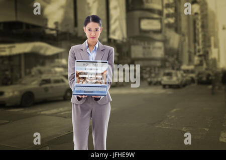 Composite image of businesswoman montrant un ordinateur portable Banque D'Images