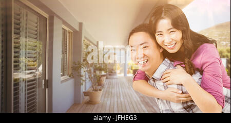 Image composite de man giving woman piggyback un Banque D'Images