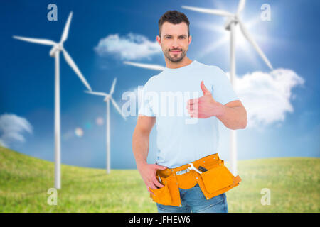 Image composite de handyman wearing tool belt with Thumbs up Banque D'Images