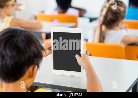 Vue arrière d'élèves using tablet pc in classroom Banque D'Images