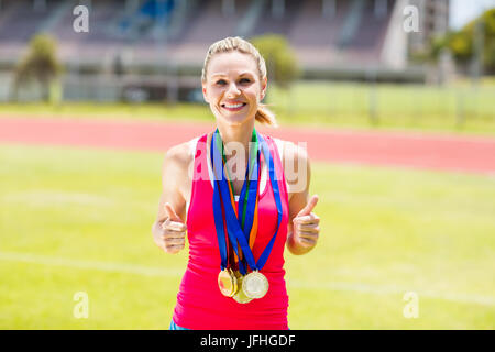 Portrait of happy female athlete avec médailles d'or Banque D'Images