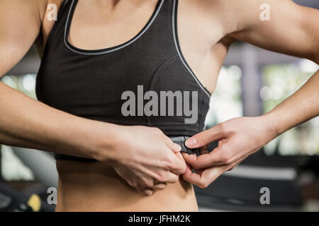 Femme dans le port de sport moniteur de fréquence cardiaque autour de sa poitrine Banque D'Images