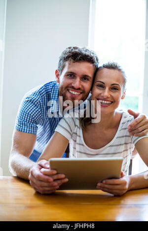 Portriat de smiling couple holding digital tablet Banque D'Images