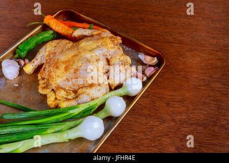 La cuisson du poulet avec des ingrédients - carotte, herbes et d'épices avant la cuisson au four. Fond sombre pour un menu livre de recettes ou de conception. Accueil destinat Banque D'Images