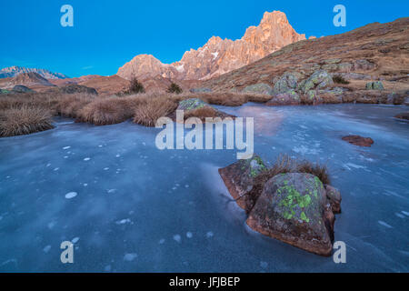 L'Europe, Italie, Trentin-Haut-Adige, petit étang glacé sur Cavallazza Piccola groupe de Lagorai, dans l'arrière-plan la montagne Mulaz et Cimon della Pala, Pale di San Martino, Dolomites Banque D'Images