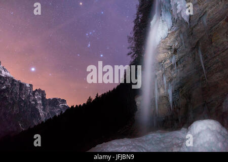 La cascade de l'enfer (Cascata dell'Inferno)à la fin de la vallée de San Lucano, Taibon Agordino, photographié en hiver sous un ciel étoilé avec la constellation d'Orion, Dolomites, Belluno, Banque D'Images