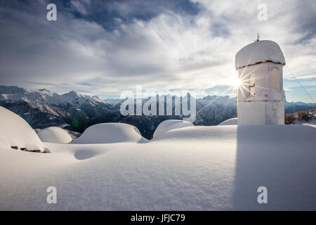 Soleil d'hiver derrière la pittoresque clocher à Alpe Scima après une forte chute de neige, Valchiavenna, Valtellina Lombardie Italie Europe Banque D'Images