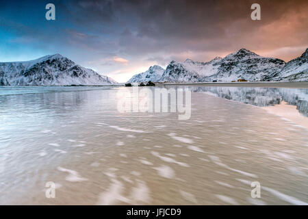 Ciel rose sur le surréel Skagsanden plage entourée de montagnes couvertes de neige, Lofoten, Norvège du Nord Europe Banque D'Images