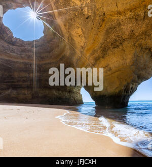 Le soleil brille à travers les rocheuses naturelles des fenêtres dans les grottes de Benagil District Faro Algarve portugal Europe Banque D'Images