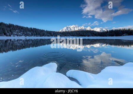 Woods et des sommets enneigés se reflètent dans l'eau claire du lac Palù Valtellina Zone Val Malenco de Lombardie Italie Europe Banque D'Images