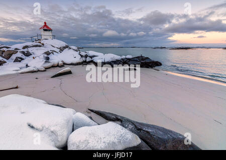 L'Arctique coloré coucher de soleil sur le phare entouré de neige et de glace l'Île Vestvagoy sable Eggum Lofoten, Norvège Europe Banque D'Images