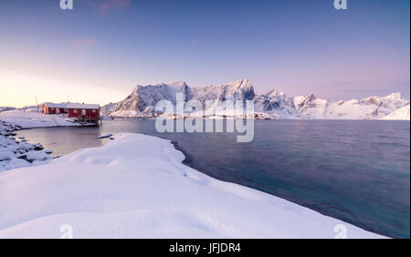 Les couleurs de l'aube les cadres de maisons de pêcheurs entouré par la mer gelée Sakrisøy Reine Nordland îles Lofoten Norvège Europe Banque D'Images