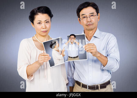 Composite image of asian woman holding a photo Banque D'Images