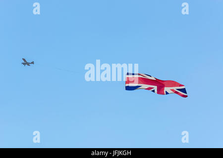 Remorquage de banderole, de petits avions moteur remorquant des bannières pour la publicité. Ici le drapeau de Grande-Bretagne. Banque D'Images