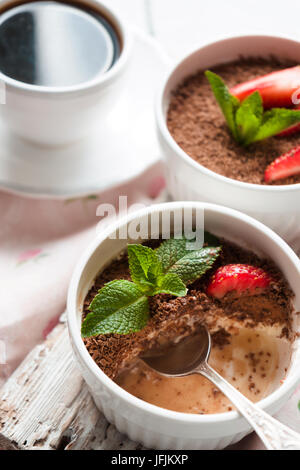 Dans les ramequins Tiramisu blanc sur la table verticale Banque D'Images