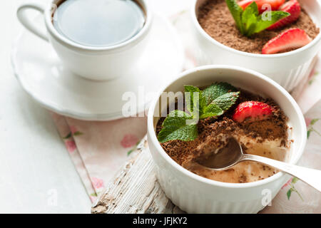 Tiramisu à la fraise et de la menthe dans les ramequins sur la table horizontale blanche Banque D'Images