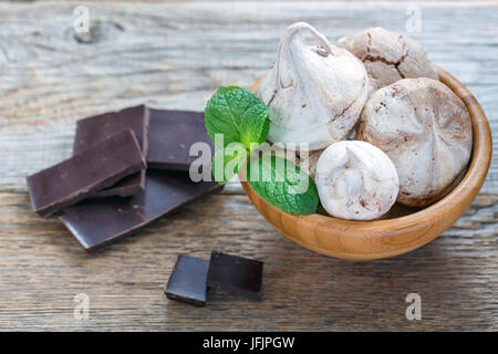 La meringue dans un bol en bois et le chocolat noir. Banque D'Images